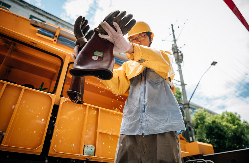 臺州黃巖區電力工作者身著厚厚的絕緣服，在40度的高溫“烤”驗下，連續奮戰2個多小時。馮靜攝