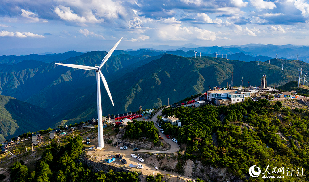 一臺臺發電機矗立在群山之中，蔚為壯觀，成為一道亮麗的風景線。人民網 章勇濤攝