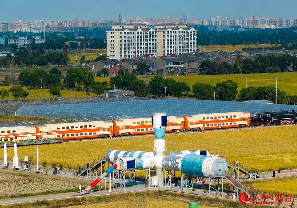 一列橙黃色的八節雙層火車“靜臥”在金黃色的稻田邊，吸引不少游客前來品咖啡、賞秋色。人民網 章勇濤攝