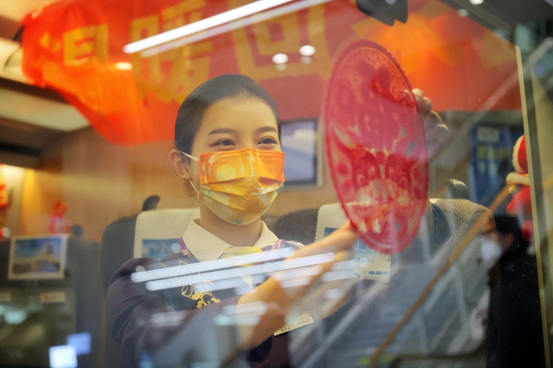 春運首日，杭州西開往武漢的G594次列車上，杭州客運段乘務人員對車廂進行布置，營造紅紅火火的過年氣氛。周圍攝