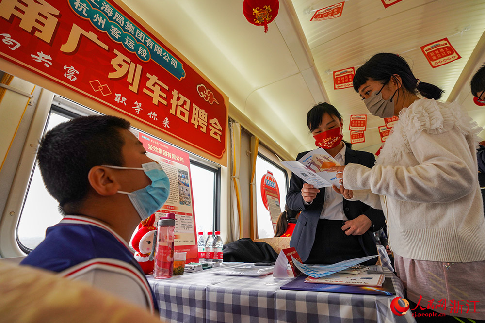 2月6日，在K210次列車上，乘客在咨詢崗位情況。人民網 章勇濤攝