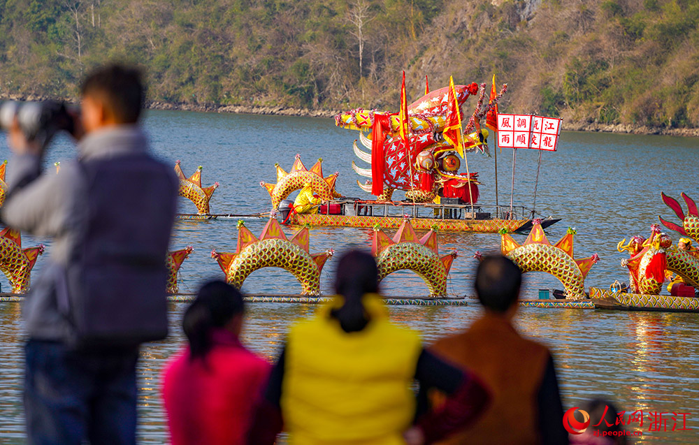 在麗水云和縣，市民觀看100多節、長達280多米的“甌江蛟龍”橫臥在江面上。人民網 章勇濤攝