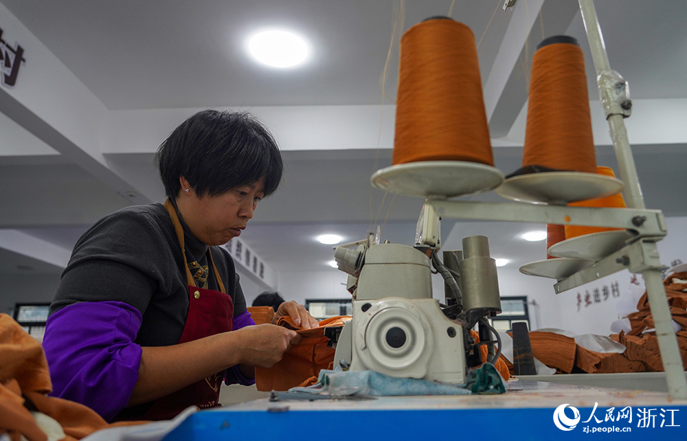 在浙江省臺州市仙居縣田市鎮水閣村“共富工坊”，工人們忙著趕制服裝。人民網 章勇濤攝