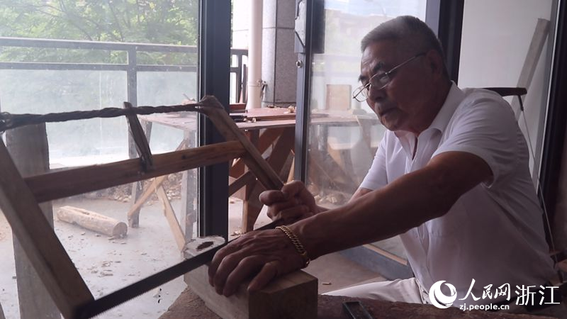 李順根在制作木雕。人民網記者 張帆攝