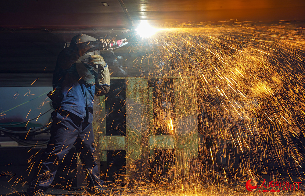 近日，在舟山一船舶修造有限公司，除銹、焊接、安裝等工位同步展開，工人們開足馬力趕制船舶訂單。人民網 章勇濤攝