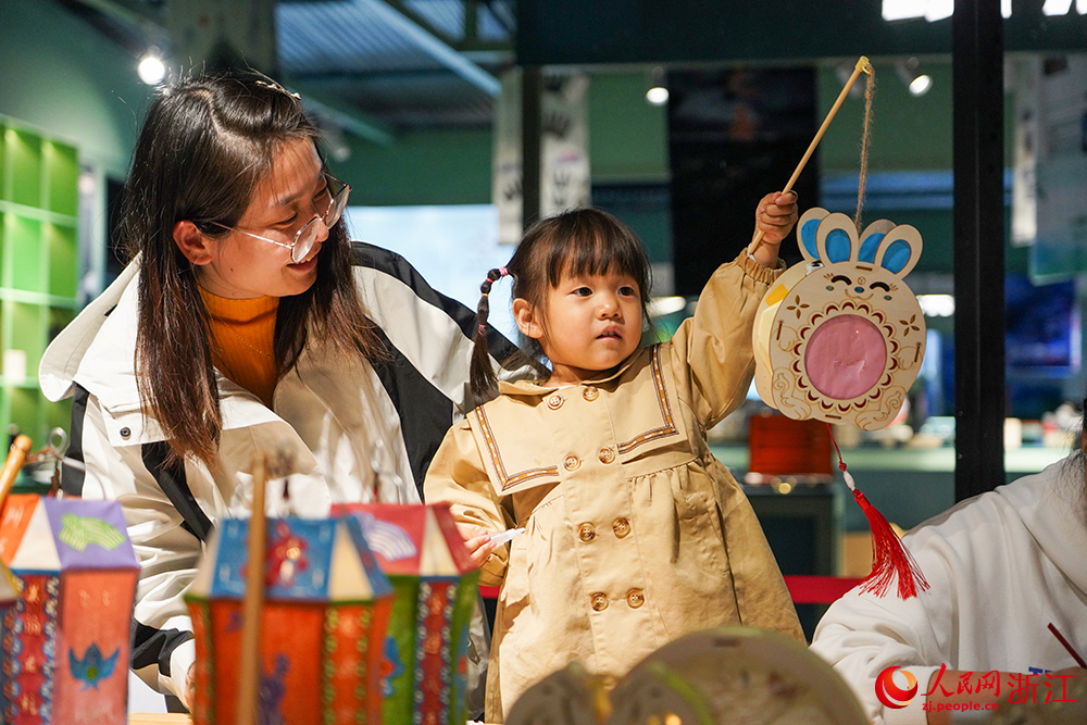 在杭州市淳安縣秀水廣場，小朋友在體驗里商仁燈。人民網 章勇濤攝