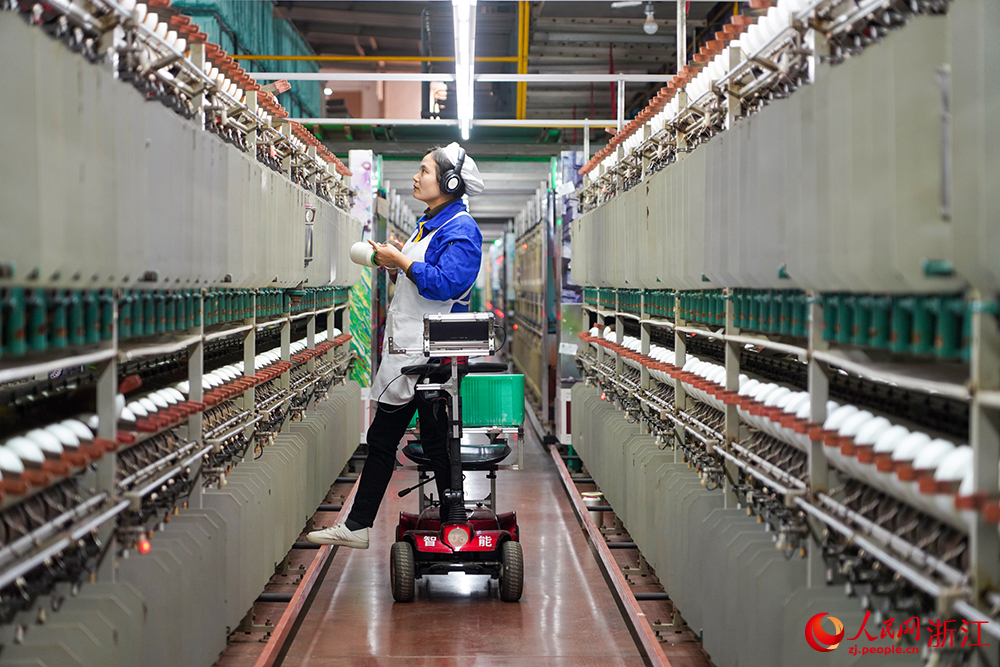 浙江省紹興市新昌縣達利絲綢智能工廠內一派繁忙，工人在生產線上趕制訂單。人民網 章勇濤攝