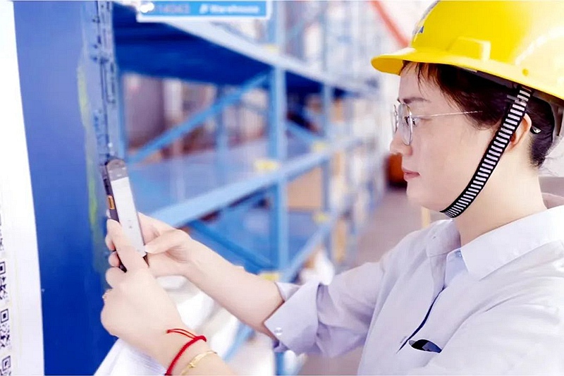 在化材公司數字倉庫的一角，保管員正拿著手持終端（PDA）掃描二維碼，從接單到出庫，全程不到5分鐘。巨化集團供圖