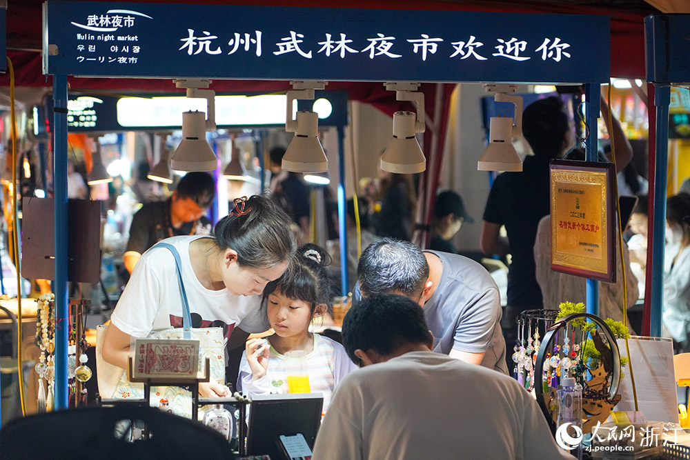 5月25日，杭州武林夜市里的手工藝品吸引游客圍觀。人民網  章勇濤攝