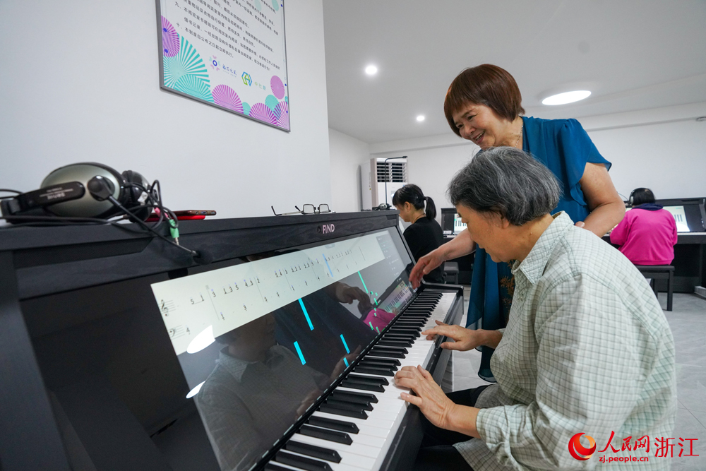 杭州翠苑街道九蓮社區居民活動室里傳出陣陣鋼琴聲，這里，一節自主鋼琴課正在火熱地進行。人民網 郭揚攝