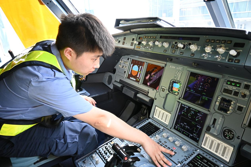 孫偉在檢查駕駛室設備。    劉卓爾 攝