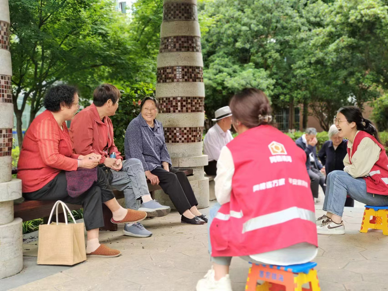 居民們出來乘涼，而穿著網格員馬甲、手提塑料小板凳的社工們的身影總是與居民們形影不離……