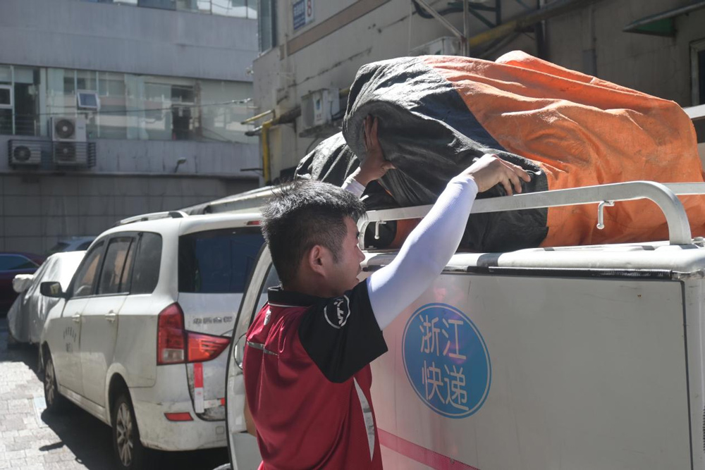 左金輪正在對包裹進行裝車。劉卓爾攝