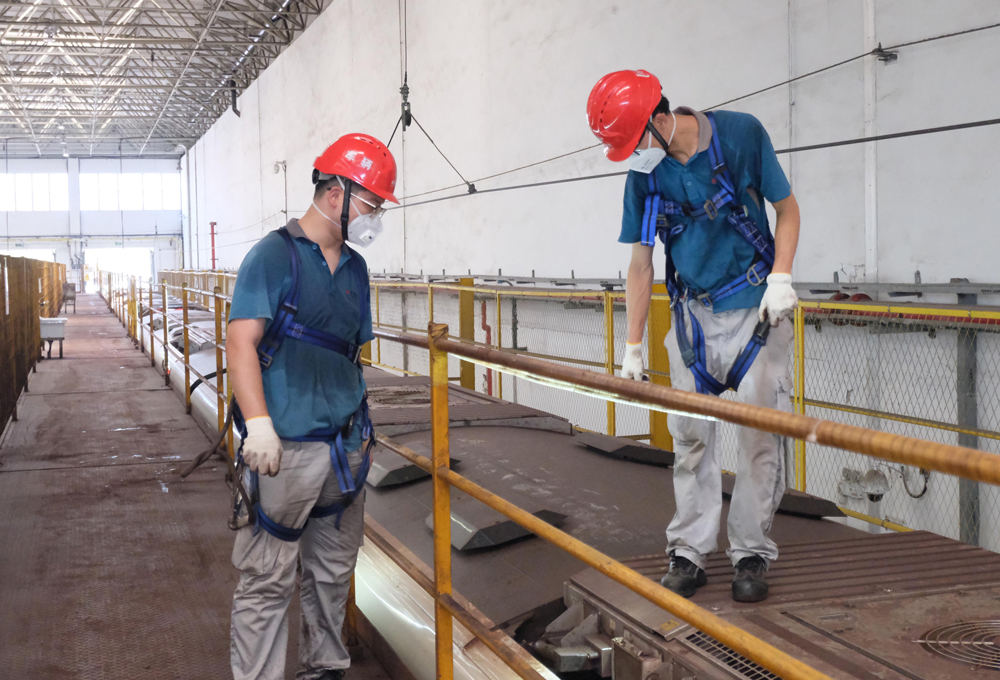 檢修員在地鐵頂部更換空調濾網。程欣攝