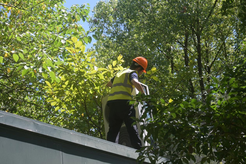 蔡曉康正在清洗空調外機。劉卓爾攝