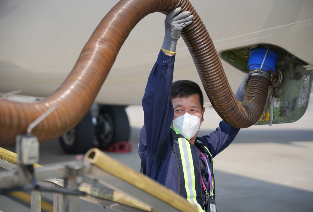 飛機排污員正在托舉污水管進行排污。吳承予攝