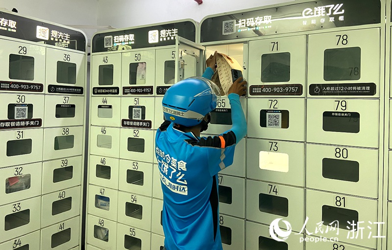 外賣小哥將餐品放入“外賣存取柜”。人民網 方彭依夢攝