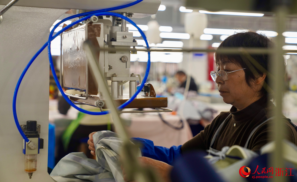 三門一家沖鋒衣企業的生產車間里，工人們正火力全開，趕制訂單。人民網記者 郭揚攝