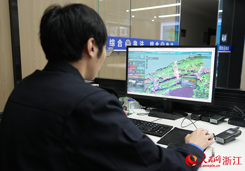 執法隊員通過觀看數智中心指揮平臺畫面，監測西湖景區情況。人民網 程欣攝