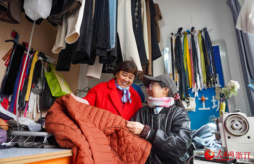 在杭州市上城區丁蘭街道綠園弄幸福鄰里坊，居民在查看縫補好的衣物。人民網 章勇濤攝