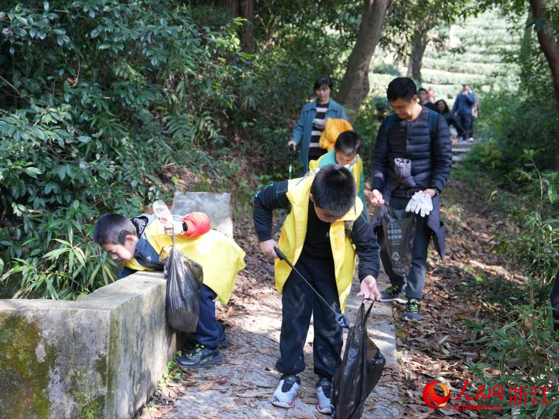 孩子們一邊爬山一邊撿拾垃圾。人民網 程欣攝