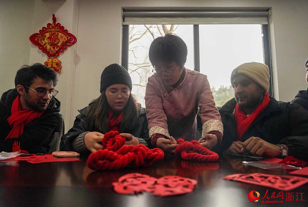 1月23日，在杭州西湖風景名勝區綜合行政執法隊，非遺老師教留學生制中國結。人民網 章勇濤攝