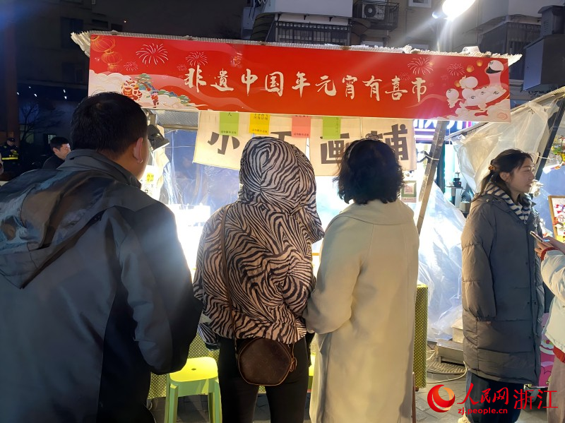 市民游客在攤位前駐足猜謎。人民網 程欣攝