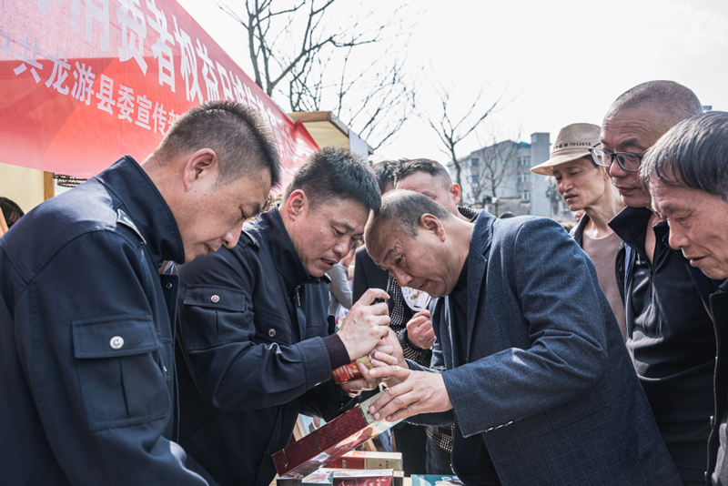 衢州煙草工作人員向群眾講解真假煙鑒別技巧。胡米伽攝