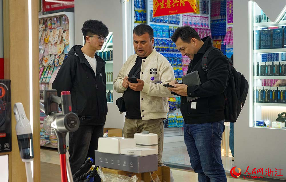 在浙江義烏國際商貿城，外商和市場經營戶在洽談生意。人民網 章勇濤攝