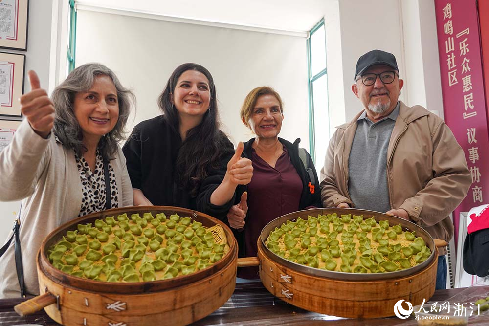 浙江省義烏市江東街道雞鳴山社區中外居民共同制作清明果。人民網 章勇濤攝
