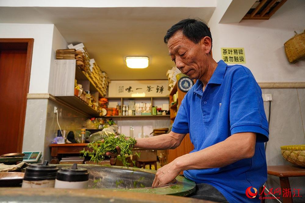 在杭州市西湖區轉塘街道桐塢村，國家級非物質文化遺產代表性項目“西湖龍井采摘和制作技藝”傳承人樊生華在炒制茶葉。人民網 章勇濤攝