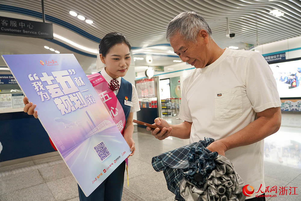 6月11日，在杭州地鐵5號線，杭港地鐵“五心服務隊”隊員引導乘客參與“我為‘十五五’規劃獻一策”活動。人民網 章勇濤攝