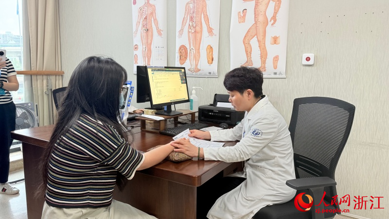 在浙江省人民醫院，中西醫結合科醫生為患者把脈問診。人民網 程欣攝
