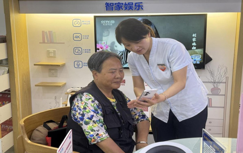 工作人員向老年用戶講解智能手機使用方法。浙江移動供圖