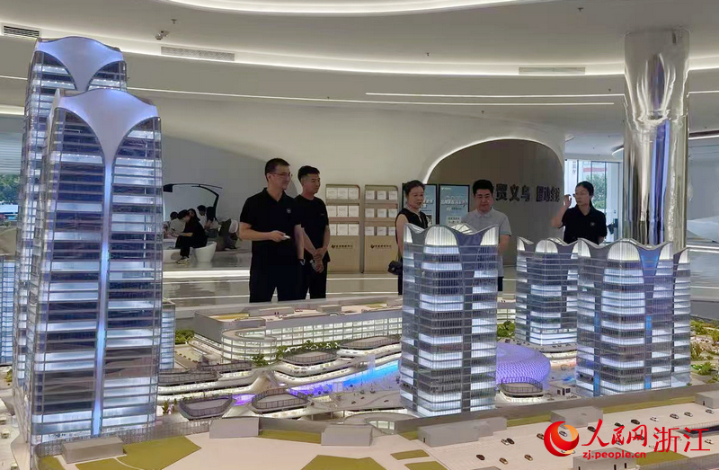 在全球數貿城沙盤前，義烏全球數貿中心副總經理朱幸平（左一）正在為客商作介紹。人民網記者 王麗瑋攝