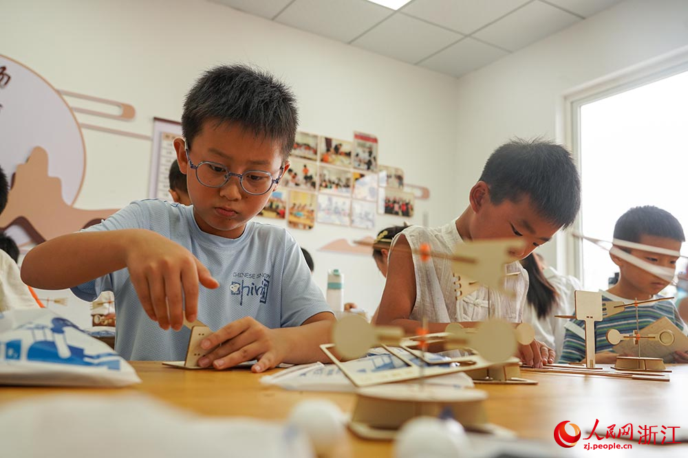 在浙江省嘉興市秀洲區洪合鎮“石榴紅”暑期課堂上，小朋友們在進行科學實驗。人民網 章勇濤攝