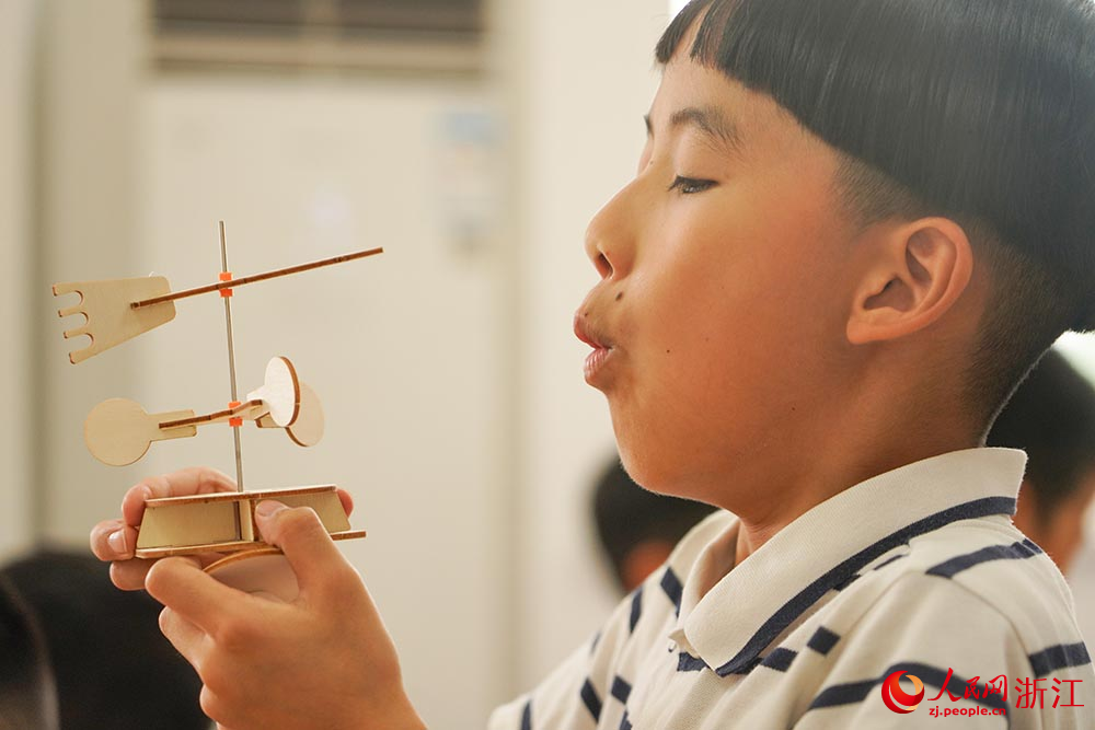 在浙江省嘉興市秀洲區洪合鎮“石榴紅”暑期課堂上，小朋友們在進行科學實驗。人民網 章勇濤攝