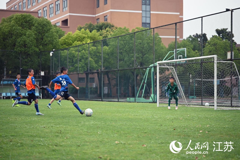 淮安工業園區實驗學校足球隊暑期對抗訓練，一名小隊員起腳打門。 人民網 鞠峰攝